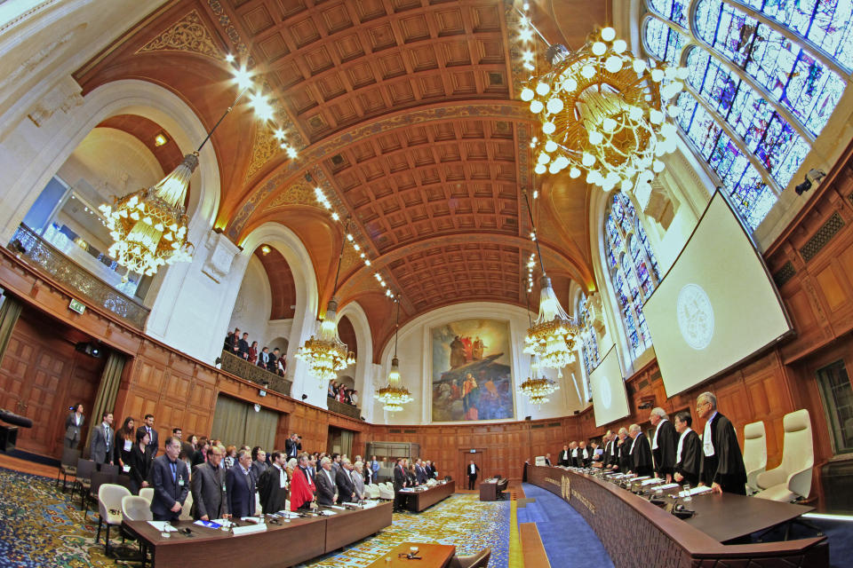Judges enter as the delegations of Iran, front row left, and the U.S., front row rear right, stand up, at the International Court of Justice, or World Court, in The Hague, Netherlands, Wednesday, Feb. 13, 2019. The court is scheduled to deliver its judgement on U.S. objections about the court's jurisdiction in the case. (AP Photo/Peter Dejong). (AP Photo/Peter Dejong)