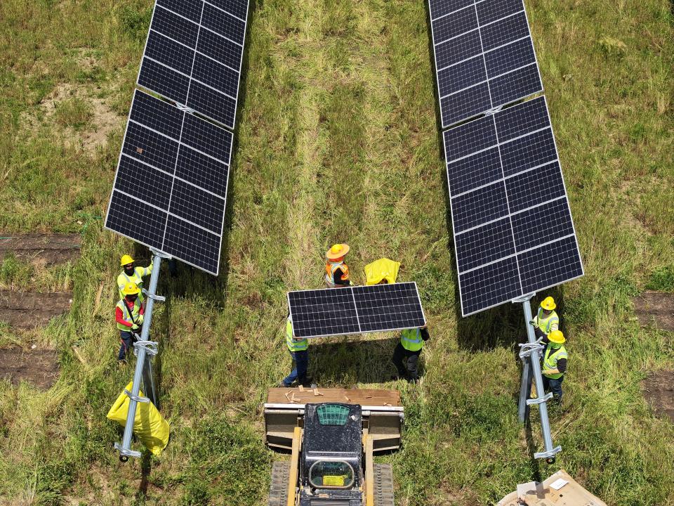 Crews install solar panels at a solar energy center under construction in Hardin County, Ohio. The panels are among the first produced by Illuminate USA, a leading U.S. solar panel manufacturer based in Pataskala.