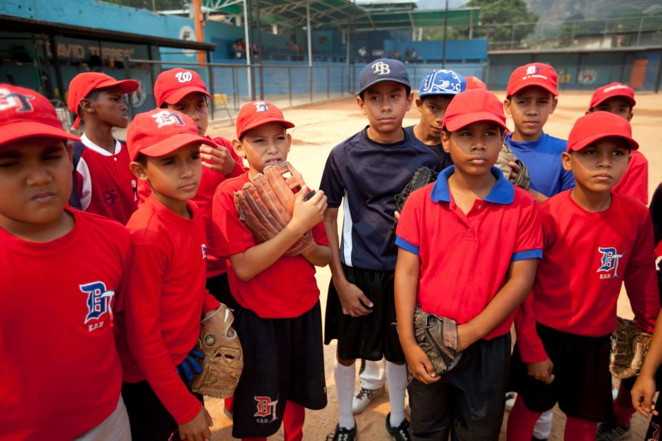 Boys listen to their coach during a baseball practice in the hometown of Detroit Tiger's Miguel Cabrera, in Maracay, Venezuela, Friday, March 28, 2014. Cabrera, 30, learned to play on this same field, now remodeled thanks to his economic support. On Friday, he signed the richest contract in baseball history, a $292 million 10-year deal with the Tigers. (AP Photo/Alejandro Cegarra)