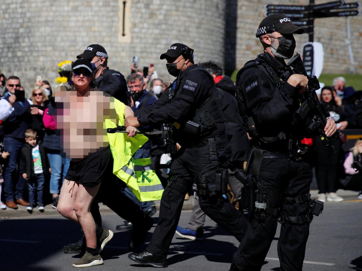 A protester runs outside Windsor Castle on the day of the funeral of Prince Philip (REUTERS/Phil Noble)