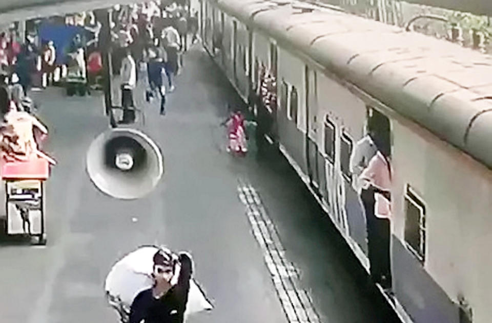 The girl holds her mother’s hand as they try to board the train (Picture: SWNS)