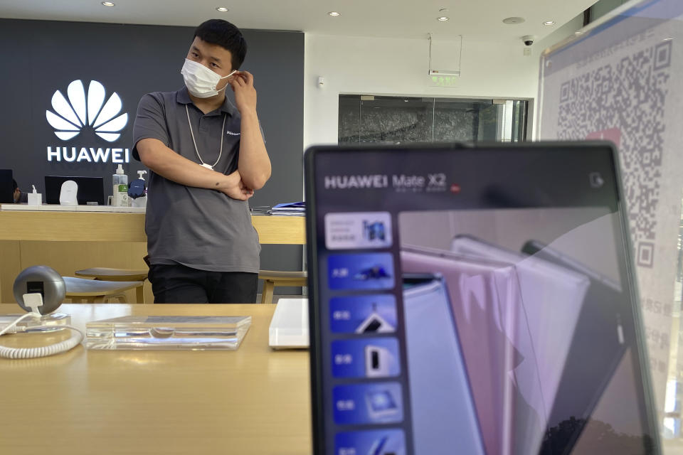 A worker waits for customers inside a Huawei store in Beijing on Wednesday, June 2, 2021. Huawei is launching its own HarmonyOS mobile operating system on its handsets as it adapts to losing access to Google mobile services two years ago after the U.S. put the Chinese telecommunications company on a trade blacklist. (AP Photo/Ng Han Guan)