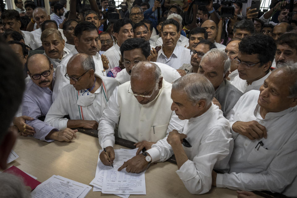 Senior Congress party leader Mallikarjun Kharge, center, signs his nomination papers for Congress party president at the party's headquarter in New Delhi, India, Friday, Sept. 30, 2022. India’s main opposition Congress party, long led by the politically powerful Nehru-Gandhi family, is set to choose a non-family member as its next president after a gap of more than two decades. (AP Photo/Altaf Qadri)