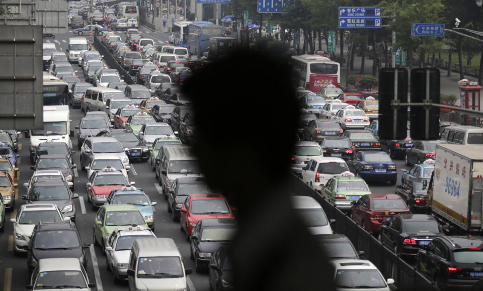 FILE - In this May 29, 2013 file photo, a street becomes clogged with traffic in Shanghai, China. Global warming is triggered by heat-trapping gases, such as carbon dioxide, that stay in the atmosphere for a century. Much of the gases still in the air and trapping heat came from the United States and other industrial nations. China is now by far the No. 1 carbon dioxide polluter, followed by the United States and India. (AP Photo/Eugene Hoshiko, File)