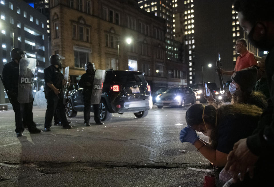 In this May 29, 2020, photo, protesters kneel in prayer in front of a police line during a protest in response to the death of George Floyd in Detroit. (Nicole Hester/Mlive.com/Ann Arbor News via AP)