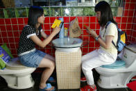 Customers look at menus on toilet seats at a toilet-themed restaurant in Shenzhen, south China's Guangdong province October 22, 2006. REUTERS/Joe Tan