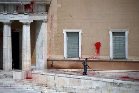 A worker cleans paint thrown by unknown attackers at the facade of the Parliament building in Athens, Greece, May 21, 2019. REUTERS/Costas Baltas