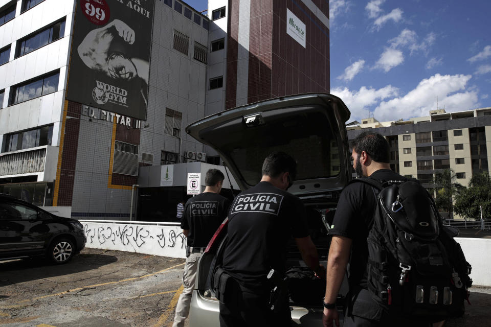 Criminal police officers arrive to retrieve the body of Debora Tereza Correia, murdered today by her boyfriend at the city education department in Brasilia, Brazil, Monday, May 20, 2019. Brazilian officials say a police officer shot his ex-girlfriend to death in her office at the city education department in Brazil's capital and then killed himself. Forty-three-year-old Debora Tereza Correia was shot three times and died immediately. (AP Photo/Eraldo Peres)