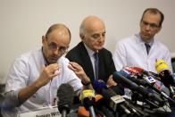 Professor Jean-Francois Payen, left, answers a journalist's question, as Professor Gerard Saillant, center, and Professor Emmanuel Gay, right, look on, during a press conference at the Grenoble hospital, in the French Alps, where former seven-time Formula One champion Michael Schumacher is being treated after sustaining a head injury during a ski accident, in Genoble , France, Monday, Dec. 30, 2013. Doctors say they cannot predict the outcome for Michael Schumacher, the retired Formula One driver who suffered a serious head injury in a ski accident. Chief anesthesiologist Jean-Francois Payen told reporters Monday that the seven-time champion is still in a medically induced coma. (AP Photo/Laurent Cipriani)