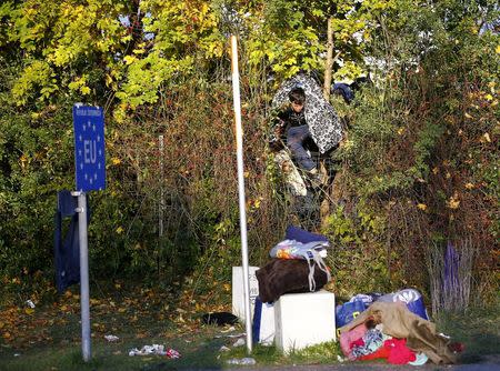 A migrant climbs over a fence at the Austrian Slowenian border near the village of Spielfeld, Austria, October 24, 2015. REUTERS/Leonhard Foeger