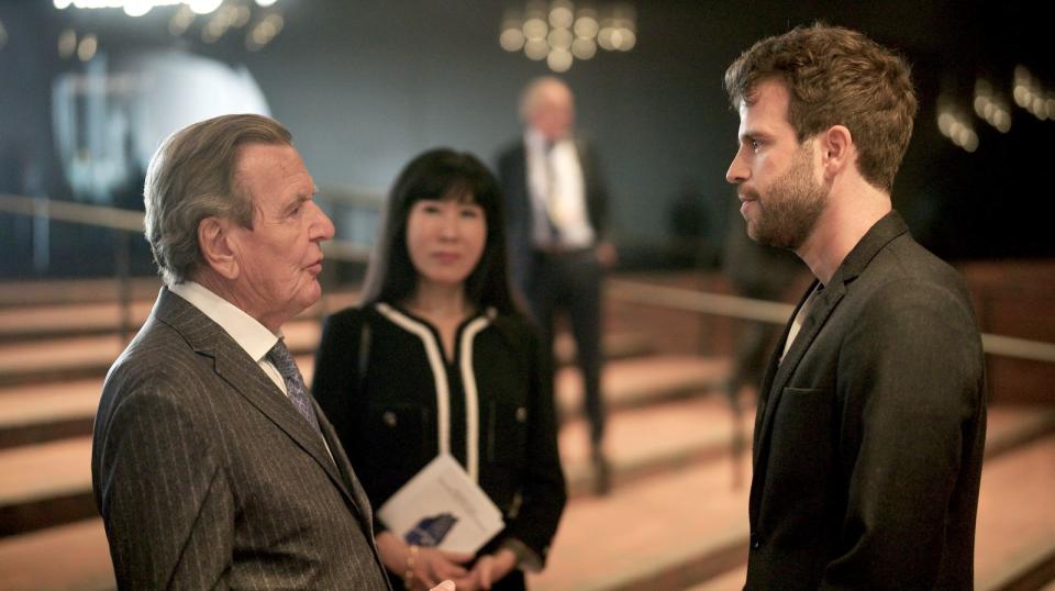 Reporter Lucas Stratmann (rechts) interviewt Altkanzler Gerhard Schröder und seiner Ehefrau Soyeon Schröder-Kim beim Festakt zur deutschen Einheit in der Hamburger Elbphilharmonie. (Bild: NDR/Sven Wettengel)