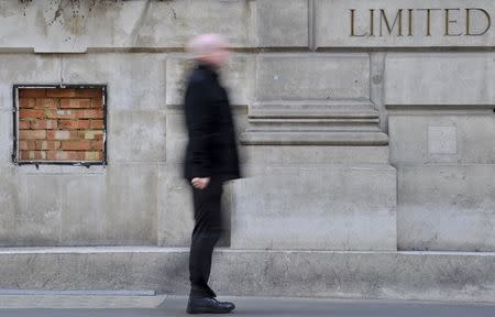A pedestrian passes a bricked-in ATM slot outside a closed bank branch in the City of London in this October 20, 2011 file photo. REUTERS/Toby Melville/Files