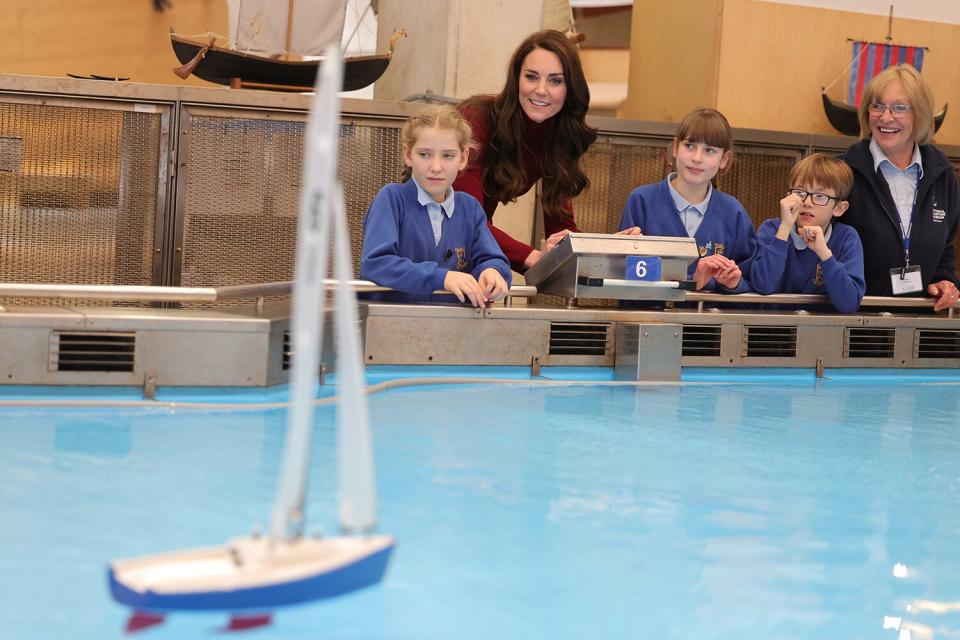 Catherine Duchess of Cornwall smiles with local school children as they take part in a model boat race during the tour of the National Maritime Museum Cornwall