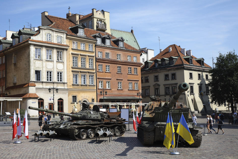 People visit an open-air exhibition of damaged and burnt-out Russian tanks and armored vehicles at the Castle Square, in Warsaw, Poland, Monday, June 27, 2022. The vehicles were captured by Ukrainian military forces during the war in the Ukraine. Ukrainian authorities announced that there are plans for similar exhibits in other European capitals such as Berlin, Paris, Madrid and Lisbon. (AP Photo/Michal Dyjuk)