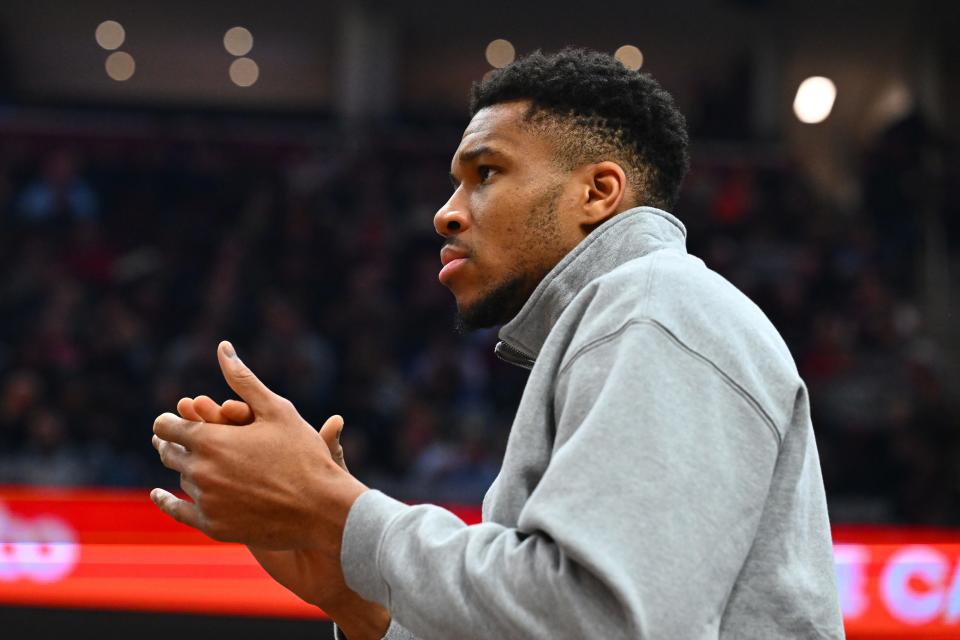 Giannis Antetokounmpo cheers the Bucks from the bench Wednesday night. He sat out the game against the Cavaliers because of a shoulder bruise.