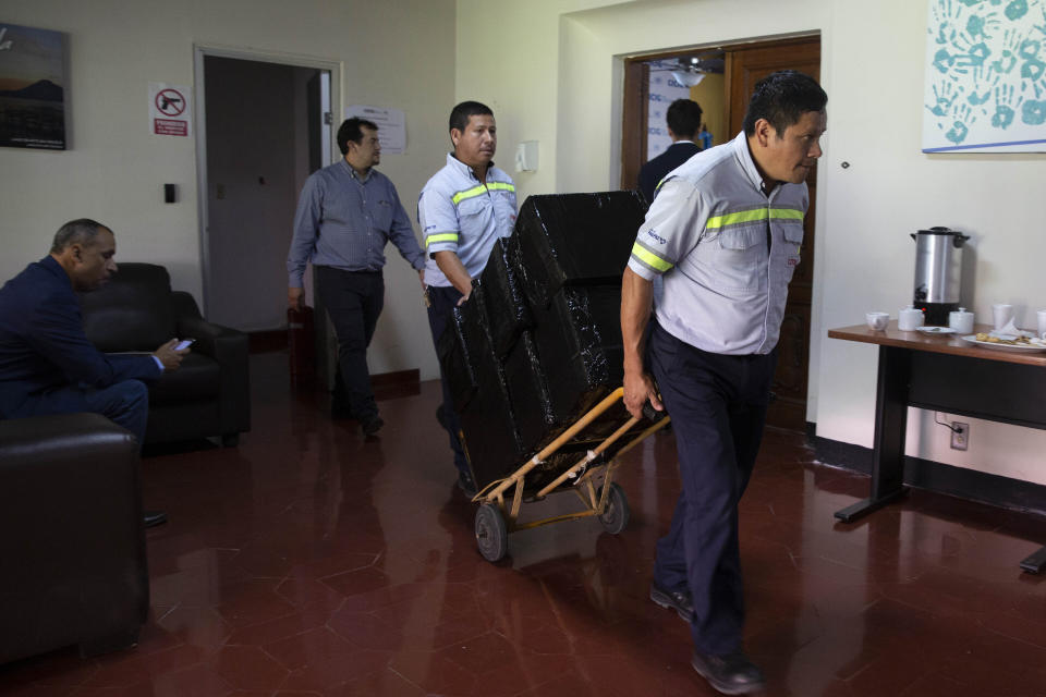 Workers move out items on a dolly as the United Nations International Commission Against Impunity, CICIG, moves out of its headquarters in Guatemala City, Wednesday, Aug. 28, 2019. The UN mission it's closing after 12 years of operation in Guatemala. (AP Photo/Moises Castillo)