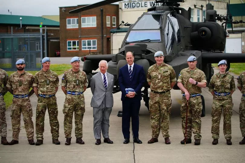 King Charles III and the Prince of Wales pose for a photograph with members of the military during a visit to the Army Aviation Centre at Middle Wallop, Hampshire -Credit:PA