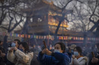 FILE - Visitors burn incense as they pray on the first day of the Lunar New Year holiday at the Lama Temple in Beijing on Jan. 22, 2023. (AP Photo/Mark Schiefelbein, File)