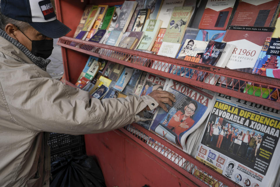 A man takes a newspaper with a photo of Free Party presidential candidate Xiomara Castro on the cover, after general elections in Tegucigalpa, Honduras, Monday, Nov. 29, 2021. Castro is holding a commanding lead as Hondurans appear poised to remove the conservative National Party after 12 years of continuous rule. (AP Photo/Moises Castillo)