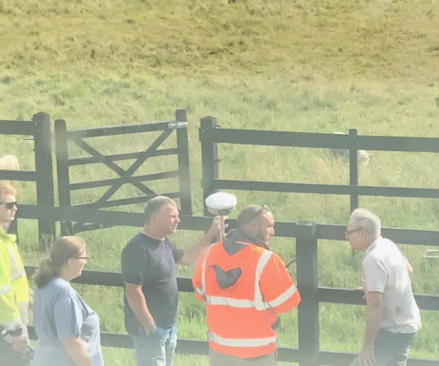 Jenny Wakerly (left) Michael Told (middle, black top) and Gary Wakerly (far right) with surveyor (middle, high vis) planning the fence construction outside The Hamblings cottage. (SWNS)