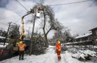 Toronto Hydro employees work to restore power in the Scarborough suburb following an ice storm in Toronto, December 27, 2013. Over 30,000 residents were left without power in Toronto Friday since the storm hit on December 22, local media reported. REUTERS/Mark Blinch (CANADA - Tags: ENVIRONMENT ENERGY)