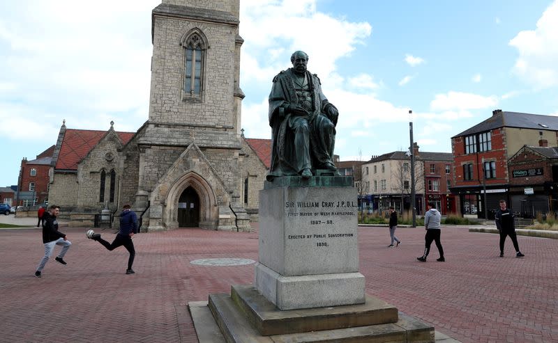 FILE PHOTO: Youths play football beside the statue of Sir William Gray, the first mayor of West Hartlepool, in Hartlepool