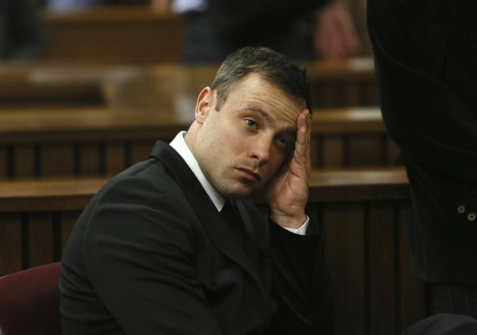 FILE — Oscar Pistorius, gestures, at the end of the fourth day of sentencing proceedings in the high court in Pretoria, South Africa, Thursday, Oct. 16, 2014. Eight years after he shot dead his girlfriend, Pistorius is up for parole, but first he must meet with her parents as part of the parole procedure. A parole hearing for Pistorius was scheduled for last month and then canceled, partly because a meeting between Pistorius and Steenkamp's parents, Barry and June, had not been arranged, lawyers for both parties told The Associated Press on Monday, Nov. 8, 2021. (AP Photo/Alon Skuy, Pool. File)