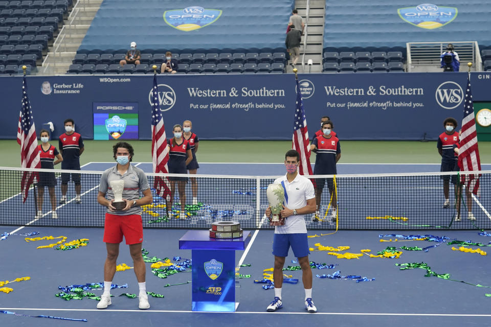 Novak Djokovic, of Serbia, front right, holds his winning trophy along with Milos Raonic, of Canada, front left, after their finals match of the Western & Southern Open tennis tournament Saturday, Aug. 29, 2020, in New York. (AP Photo/Frank Franklin II)