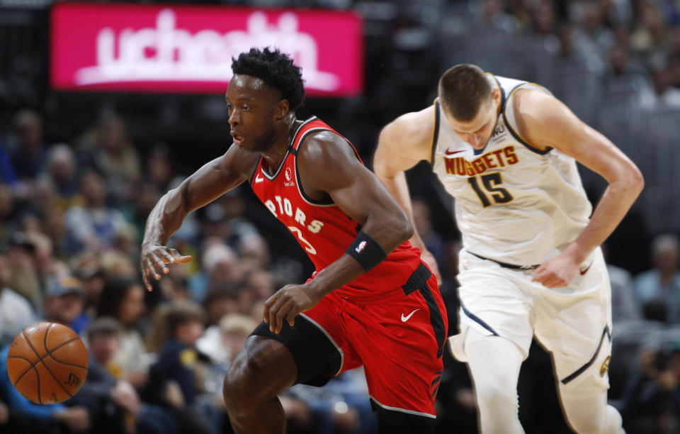 Toronto Raptors forward OG Anunoby, front, pursues the ball as Denver Nuggets center Nikola Jokic pursues in the first half of an NBA basketball game Sunday, March 1, 2020. (AP Photo/David Zalubowski)