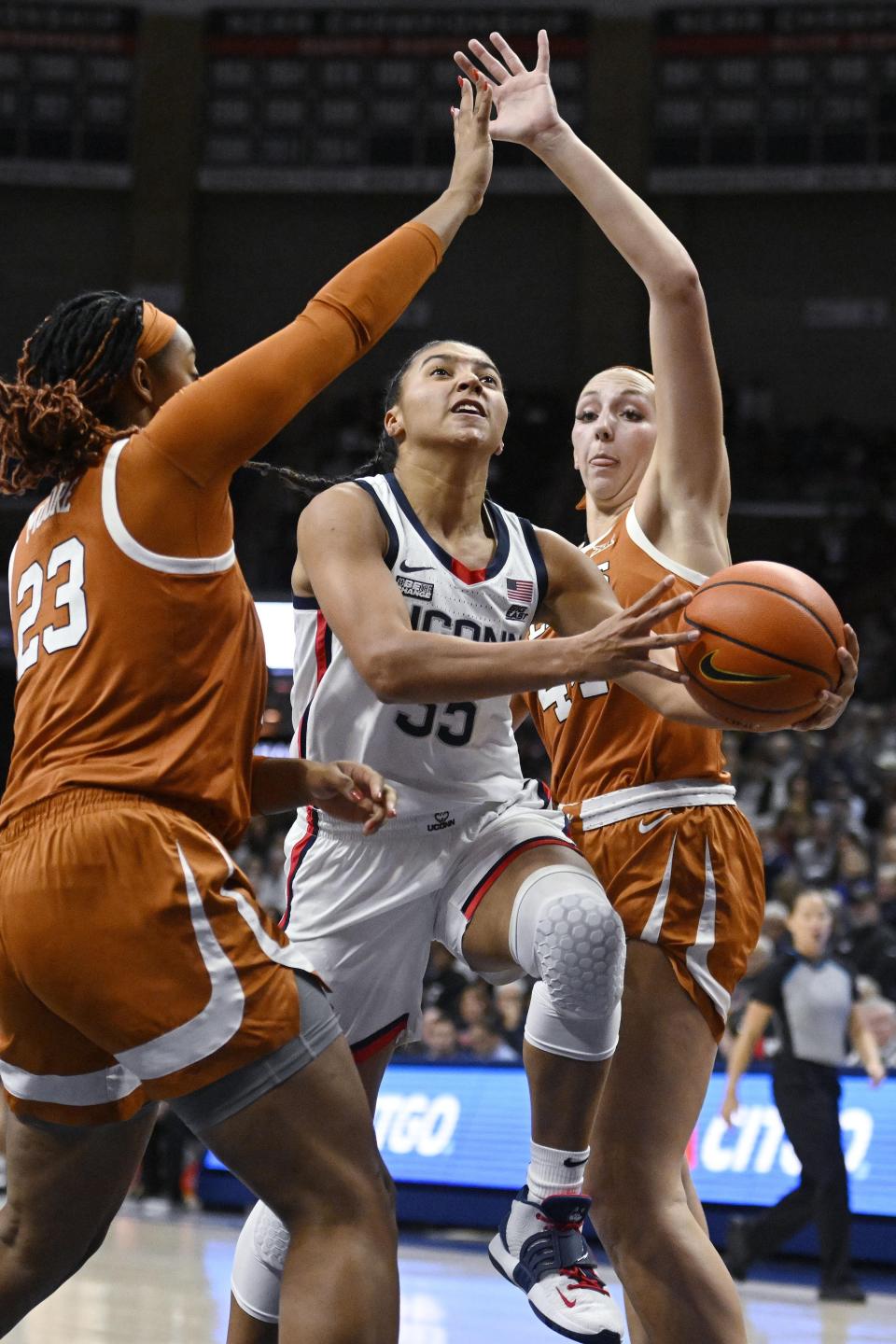 Connecticut's Azzi Fudd, center, splits the defense of Texas' Aaliyah Moore, left, and Taylor Jones, right, during the first half of an NCAA college basketball game, Monday, Nov. 14, 2022, in Storrs, Conn. (AP Photo/Jessica Hill)