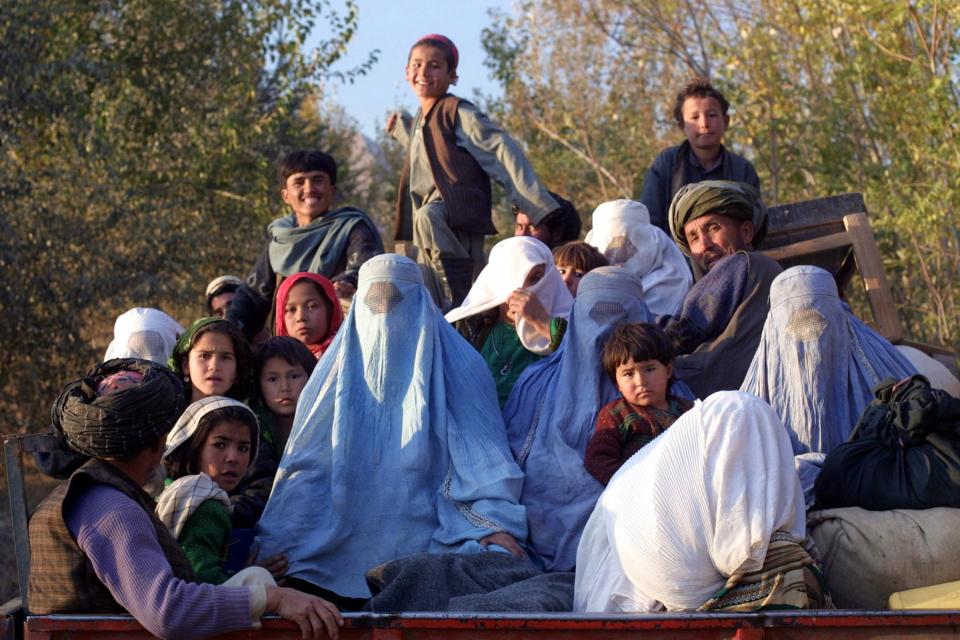 Residents of the northeastern Afghan village of Kalaqata in Takhar province fleeing the frontline area as US fighter planes bomb Taliban positions nearby, in November 2001 (AFP via Getty Images)