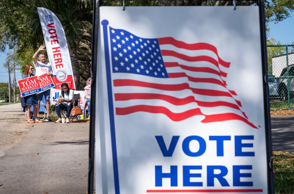 Supporters wave at cars entering the parking lot at Pompey Park during election day on March 19, 2024 in Delray Beach, Florida.