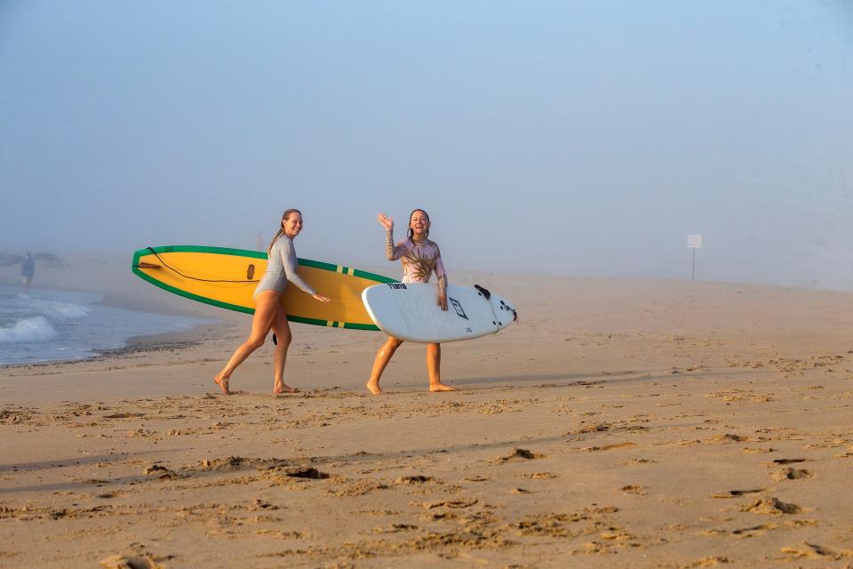 Kelly Sinatra and Jessica Slemons, both of Asbury Park, surf in the early morning fog in Asbury Park, NJ Thursday, July 6, 2023.