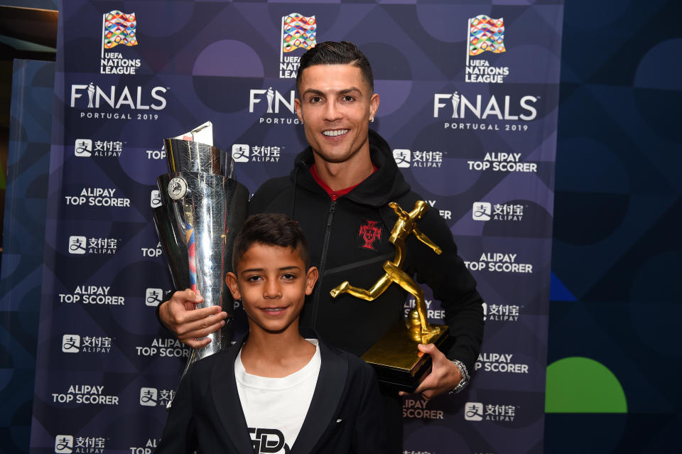 PORTO, PORTUGAL - JUNE 09: Cristiano Ronaldo of Portugal poses with his son, Cristiano Ronaldo Jr, along with his Top Scorer of the Competition award and the UEFA Nations League Trophy following the UEFA Nations League Final between Portugal and the Netherlands at Estadio do Dragao on June 09, 2019 in Porto, Portugal. (Photo by Denis Doyle - UEFA/UEFA via Getty Images)