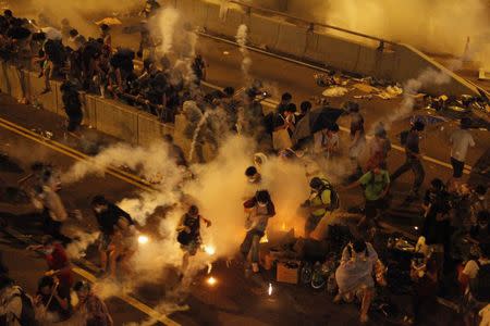 Riot police fire teargas to disperse protesters after thousands of demonstrators blocked the main street to the financial Central district outside the government headquarters in Hong Kong September 29, 2014. REUTERS/Stringer