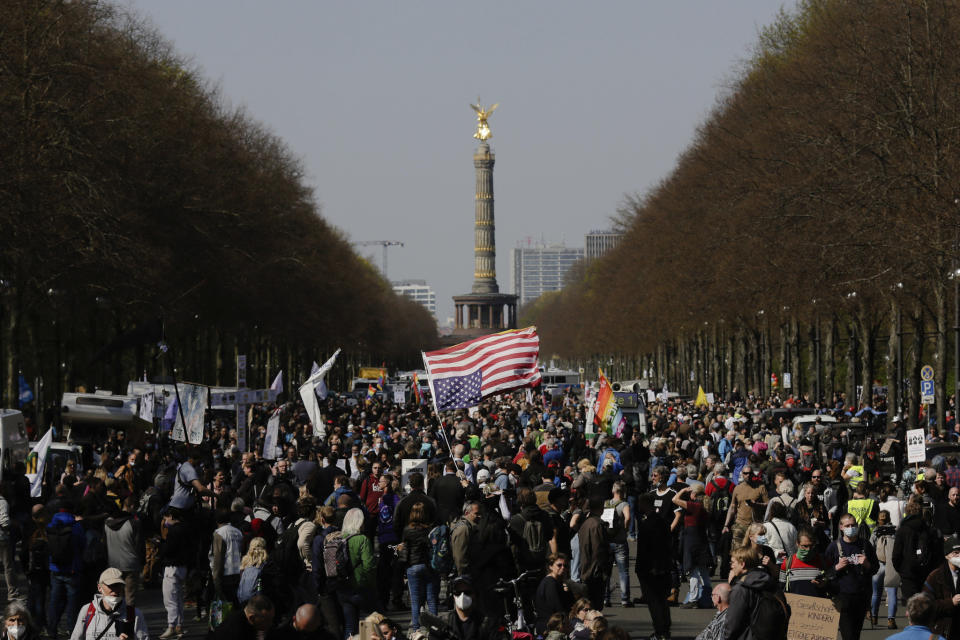 A demonstrator waves a US flag as he attends a protest rally against the German government's policy to battle the corona virus pandemic in Berlin, Germany, Wednesday, April 21, 2021.The parliament decides on a law that gives the federal government more power to battle the coronavirus pandemic. (AP Photo/Markus Schreiber)