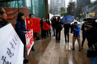 Supporters, including Ada Yu, hold signs and Chinese flags in the rain outside the B.C. Supreme Court bail hearing of Huawei CFO Meng Wanzhou, who was held on an extradition warrant in Vancouver, British Columbia, Canada December 11, 2018. REUTERS/Lindsey Wasson