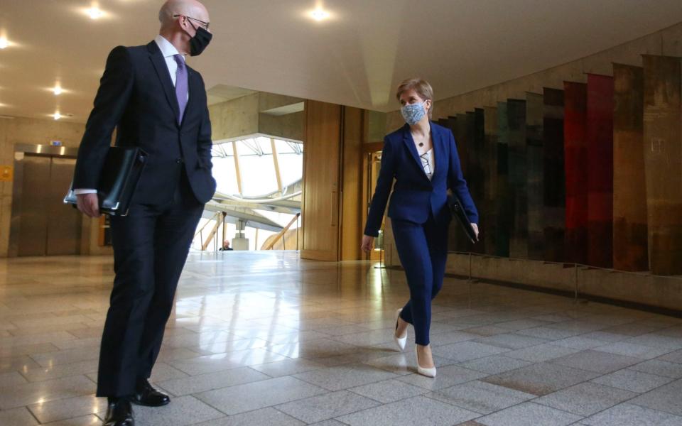 First Minister Nicola Sturgeon and Deputy First Minister John Swinney arrive for First Minister's Questions (FMQs) in the debating chamber of the Scottish Parliament in Edinburgh - PA