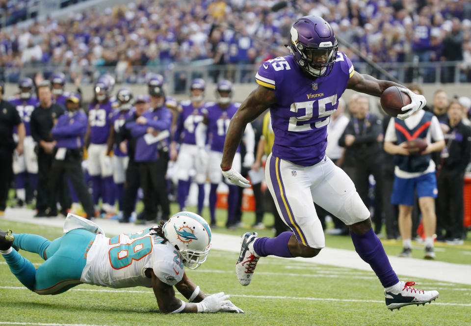 Minnesota Vikings running back Latavius Murray (25) breaks a tackle by Miami Dolphins cornerback Bobby McCain, left, during an 18-yard touchdown run in the first half of an NFL football game, Sunday, Dec. 16, 2018, in Minneapolis. (AP Photo/Bruce Kluckhohn)