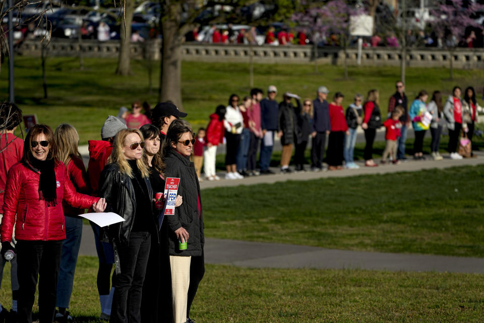 People hold hands and link arms during the Linking Arms for Change human chain Wednesday, March 27, 2024, in Nashville, Tenn. The event was to commemorate the one-year anniversary of the Covenant School mass shooting. Three students and three adults were killed in the incident. (AP Photo/George Walker IV)