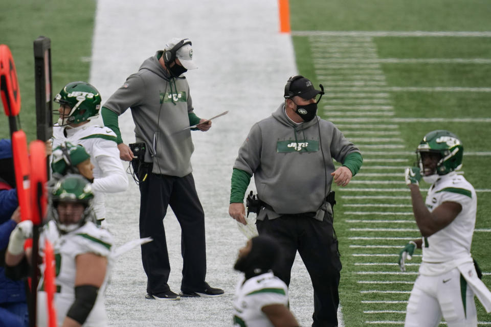 New York Jets head coach Adam Gase, center, checks his play sheet along the sideline in the first half of an NFL football game against the New England Patriots, Sunday, Jan. 3, 2021, in Foxborough, Mass. At right is special teams coordinator Brant Boyer. (AP Photo/Charles Krupa)