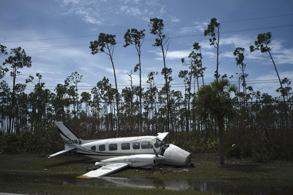 A broken plane lays on the side of a road in the Pine Bay neighborhood in the aftermath of Hurricane Dorian in Freeport, Bahamas, Wednesday, Sept. 4, 2019. Rescuers trying to reach drenched and stunned victims in the Bahamas fanned out across a blasted landscape of smashed and flooded homes Wednesday, while disaster relief organizations rushed to bring in food and medicine. (AP Photo/Ramon Espinosa)