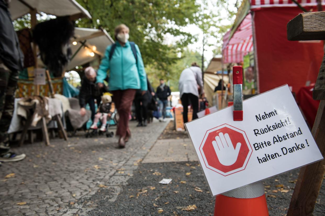 A sign reading "Please keep your distance. Thank you." is seen at the weekly market in Berlin Kreuzberg on October 20, 2020 in Berlin. - The Berlin Senate has tightened the corona requirements in view of the rising number of infections. The state government decided to make masks compulsory for markets and ten busy streets in the capital, as the Senate announced after the session. It also made the "urgent recommendation" to wear a mask in public places where the minimum distance of 1.5 metres cannot be maintained. (Photo by STEFANIE LOOS / AFP) (Photo by STEFANIE LOOS/AFP via Getty Images)