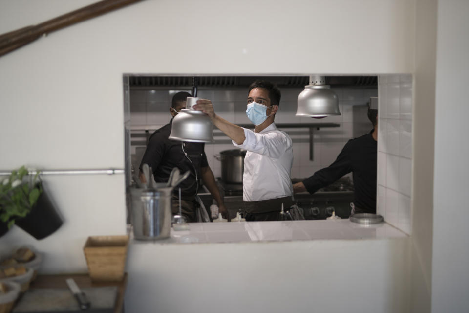 A chef prepares his seafood restaurant to receive its first customers since lockdown measures were imposed to stop the spread of the coronavirus in Marseille, southern France, Tuesday, June 2, 2020. The French way of life resumes Tuesday with most virus-related restrictions easing as the country prepares for the summer holiday season amid the pandemic. (AP Photo/Daniel Cole)