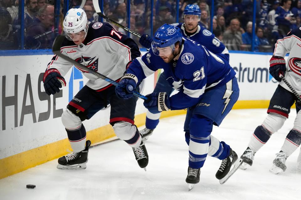 Tampa Bay Lightning center Brayden Point (21) and Columbus Blue Jackets defenseman Tim Berni (75) chase a loose puck during the second period of an NHL hockey game Tuesday, Jan. 10, 2023, in Tampa, Fla. (AP Photo/Chris O'Meara)