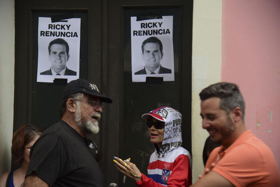 Posters of Gov. Ricardo Rosselló below the Spanish message "Ricky resign" hang during a protest near La Fortaleza governor's residence in San Juan, Puerto Rico, Sunday, July 14, 2019. Protesters are demanding Gov. Ricardo Rosselló step down for his involvement in a private chat in which he used profanities to describe an ex-New York City councilwoman and a federal control board overseeing the island's finance. (AP Photo/Carlos Giusti)
