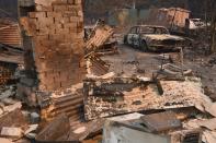 A vintage Jaguar car sits in ruins after a bushfire destroyed a property in Old Bar, 350km north of Sydney on November 10, 2019. Firefighters in eastern Australia were on November 10, 2019 assessing damage from ferocious bushfires that have devastated communities and rushing to prepare for "bad, if not worse" conditions expected to flare in the coming days. (Photo by PETER PARKS/AFP via Getty Images)