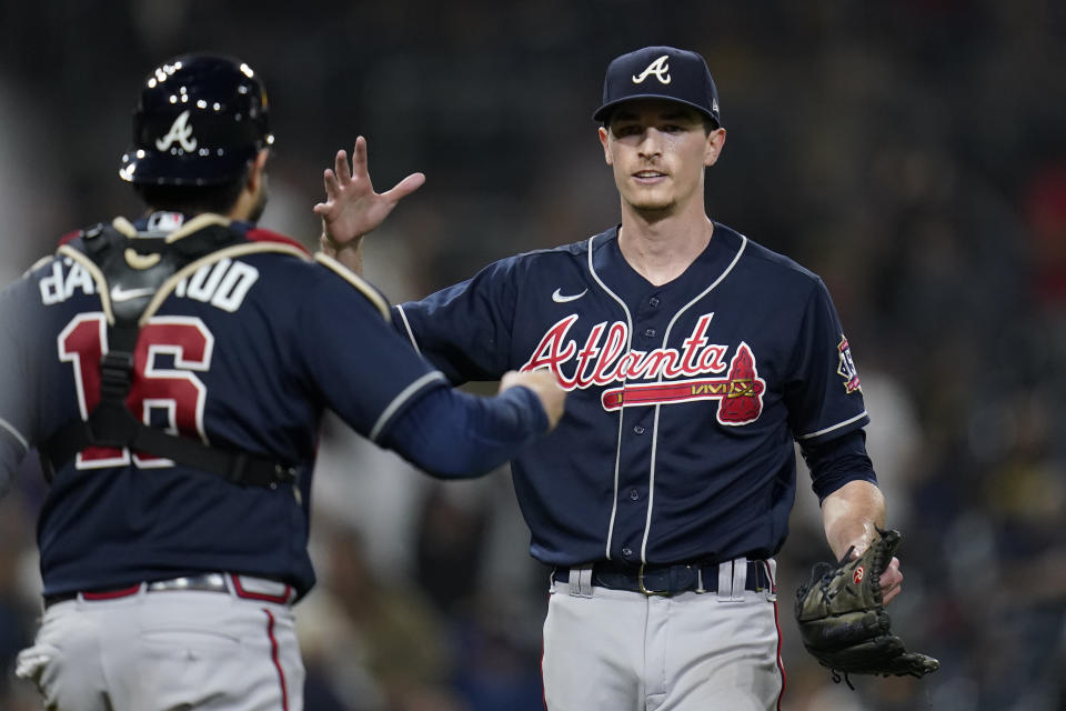 Atlanta Braves starting pitcher Max Fried, right, celebrates with catcher Travis d'Arnaud after throwing a complete game as the Braves defeated the San Diego Padres 4-0 in the baseball game Friday, Sept. 24, 2021, in San Diego. (AP Photo/Gregory Bull)