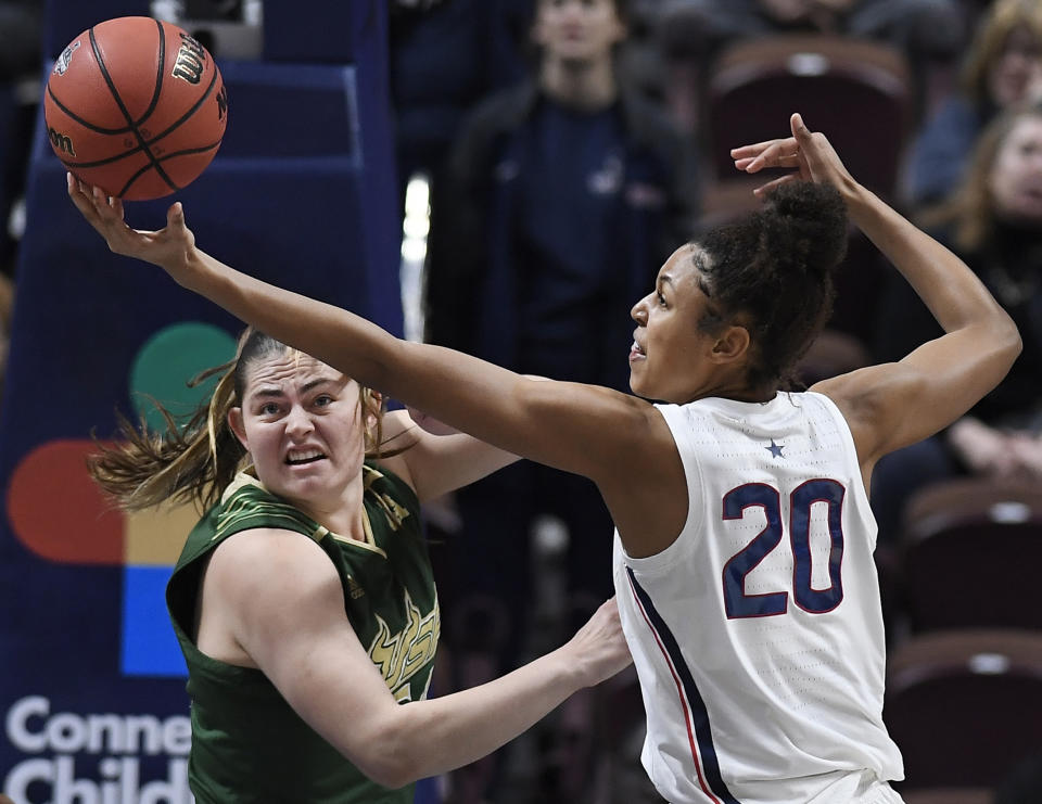 Connecticut's Olivia Nelson-Ododa (20) reaches a rebound over South Florida's Alyssa Rader during the first half of an NCAA college basketball game in the American Athletic Conference women's tournament semifinals, Sunday, March 10, 2019, at Mohegan Sun Arena in Uncasville, Conn. (AP Photo/Jessica Hill)