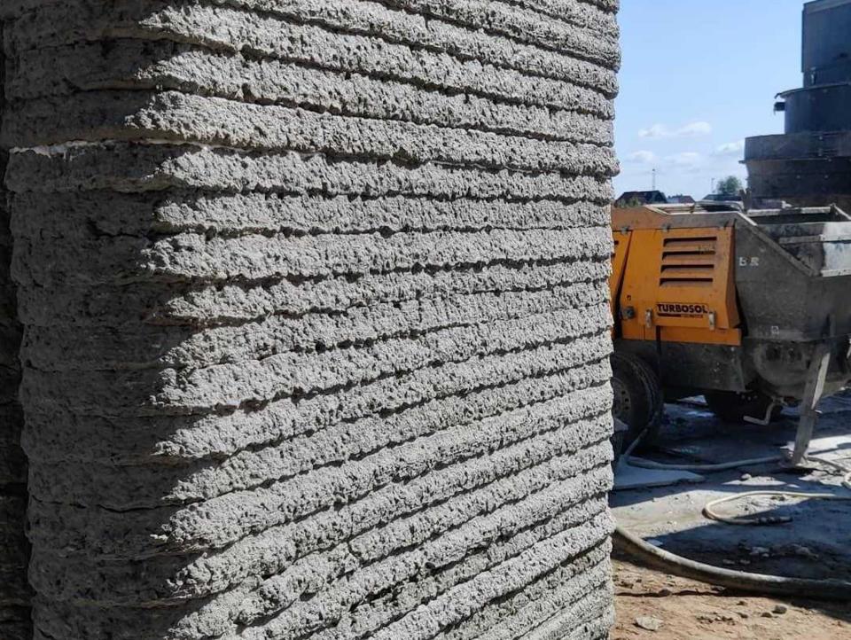 The walls of a 3D printed home among a construction site.